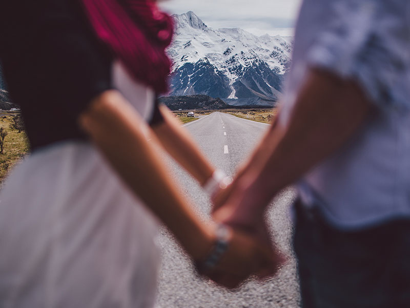 A couple holding hands on the state line.