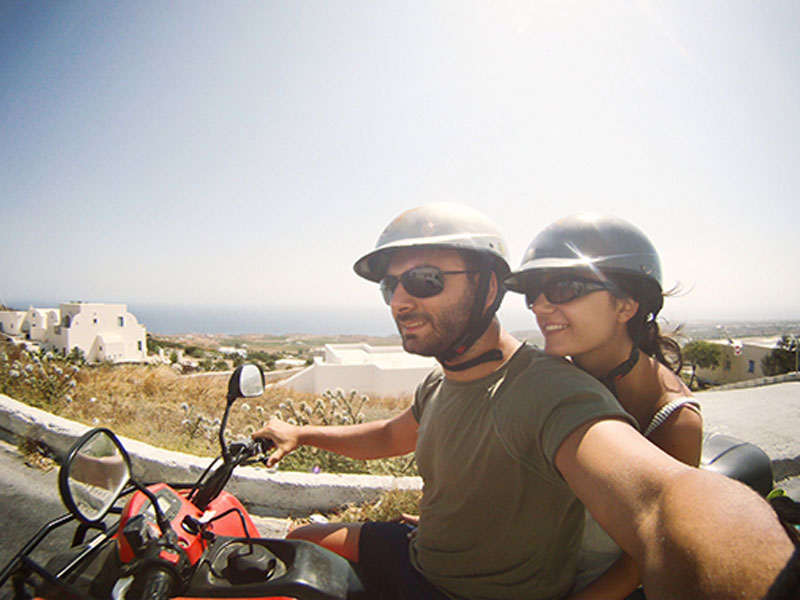 A couple on a scooter traveling together.