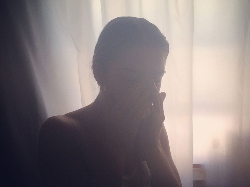 A woman upset in her room because she's going through a breakup.