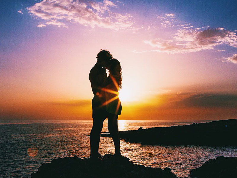 Two people having a summer love on a beach.