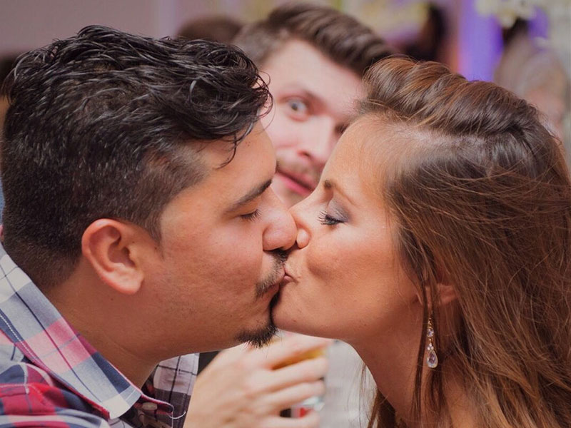 A single guy living the single life watching a happy couple kiss.