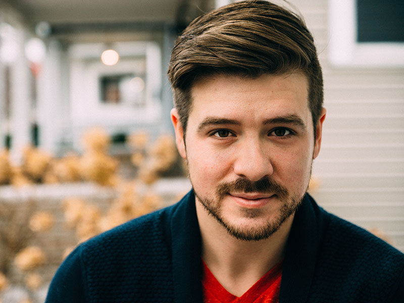 A not so nice nice guy standing in front of his house.