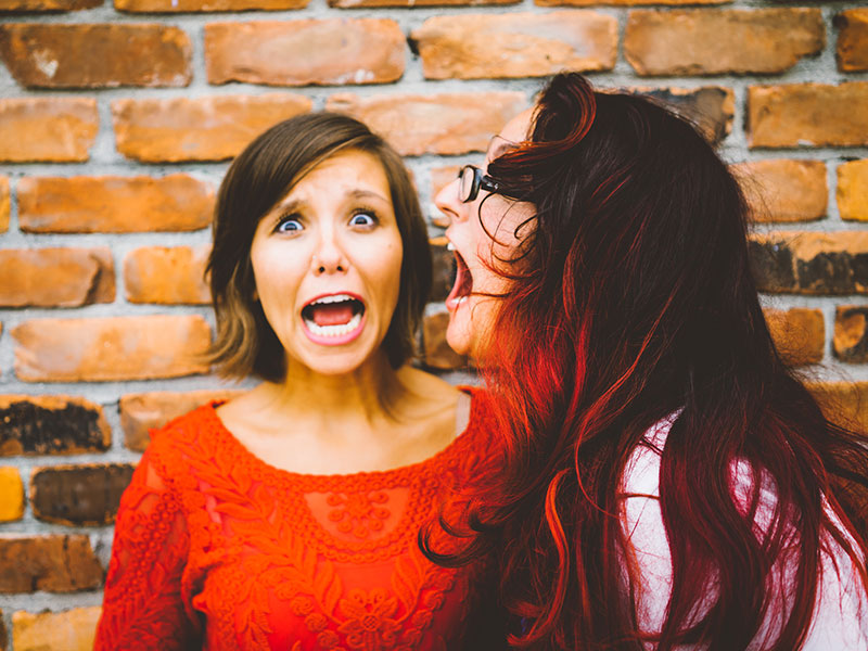 A woman and her partner being silly and yelling in a mock fight.