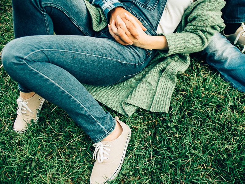 A young, millennial couple holding hands.