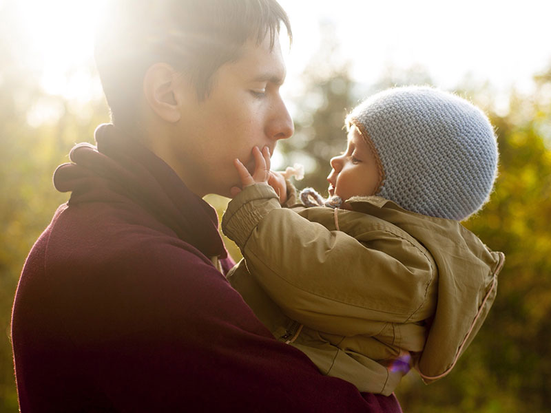 A man who is dating someone with kids playing with a baby.