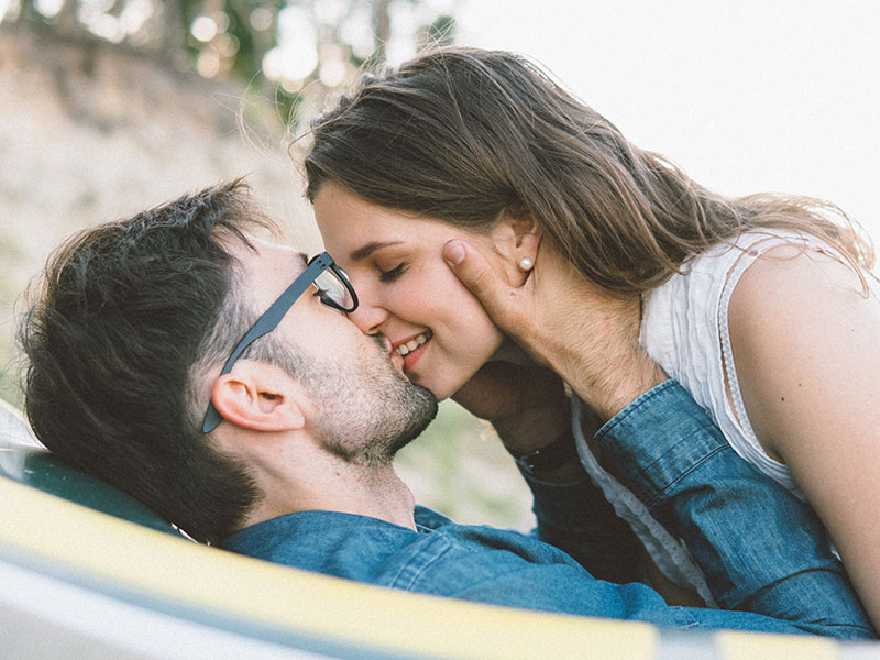 A woman who figured out dating meaning kissing her boyfriend and smiling.