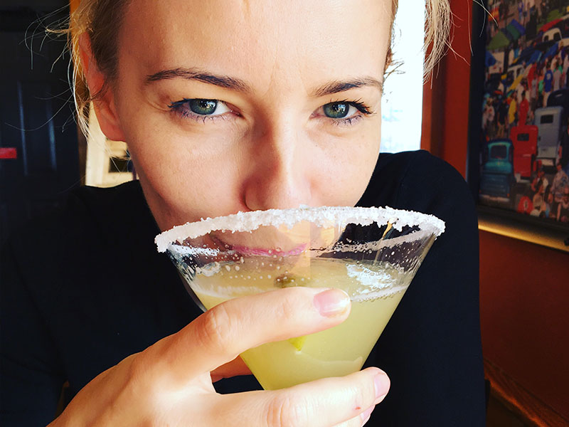 A woman who hates dating taking a sip while on a dating and smiling while thinking of these dating tips.