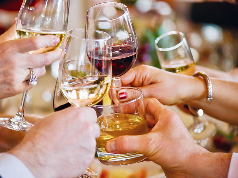 A family cheersing around the Thanksgiving day table.