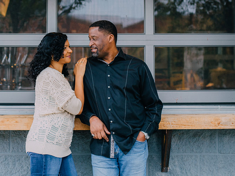 A woman telling a man "I need space" while patting his shoulder outside a coffeeshop.
