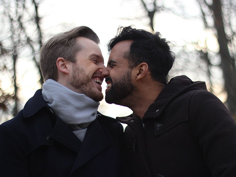 A gay couple touching noses and laughing after they met by going on fewer, but better, dates.