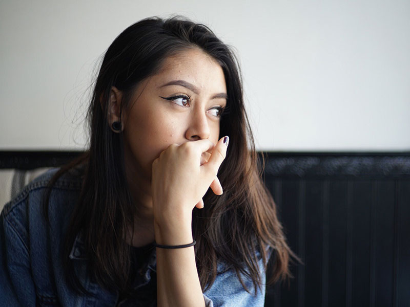 A woman asking herself if it's a good idea to have no contact with your ex or not while looking out a window.