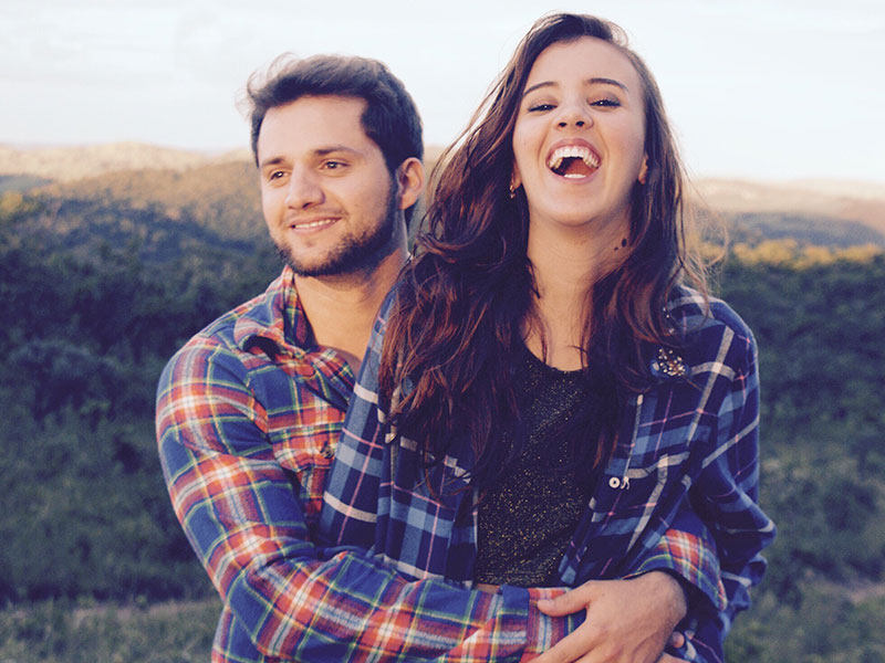 A guy who took these flirting tips, hugging and lifting up the girl he's with while she laughs and flirts back.