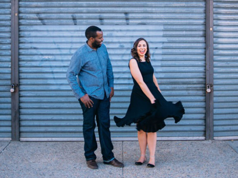 A couple that learned the difference between healthy vs. unhealthy relationships laughing while the woman spins in a circle