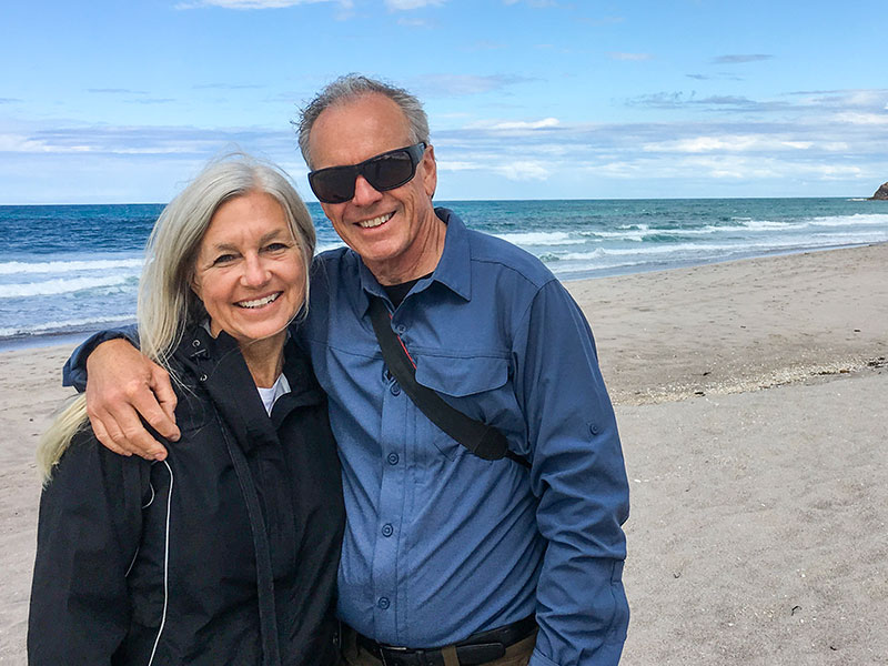 A happy couple who listened to these senior dating tips smiling on the beach while having a great time.