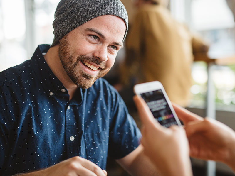 A guy with a woman who's sending him one of these texts guys love to receive, laughing and flirting.