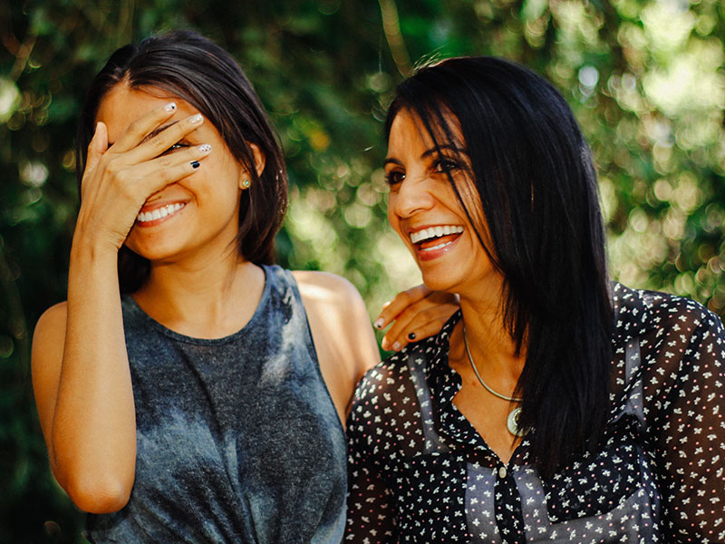 A woman dating over 50 laughing with her adult child.