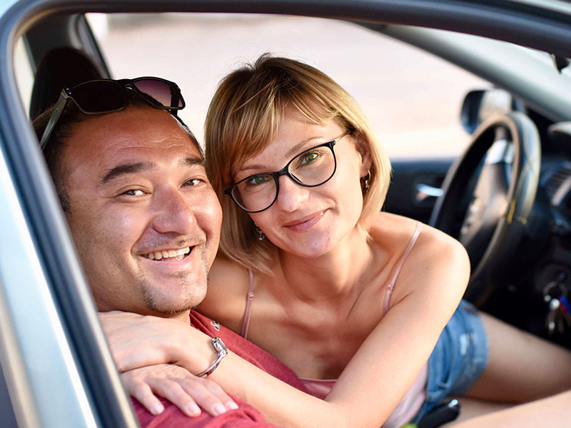 A woman who listened to this relationship advice for women, smiling and hugging her boyfriend in the car.