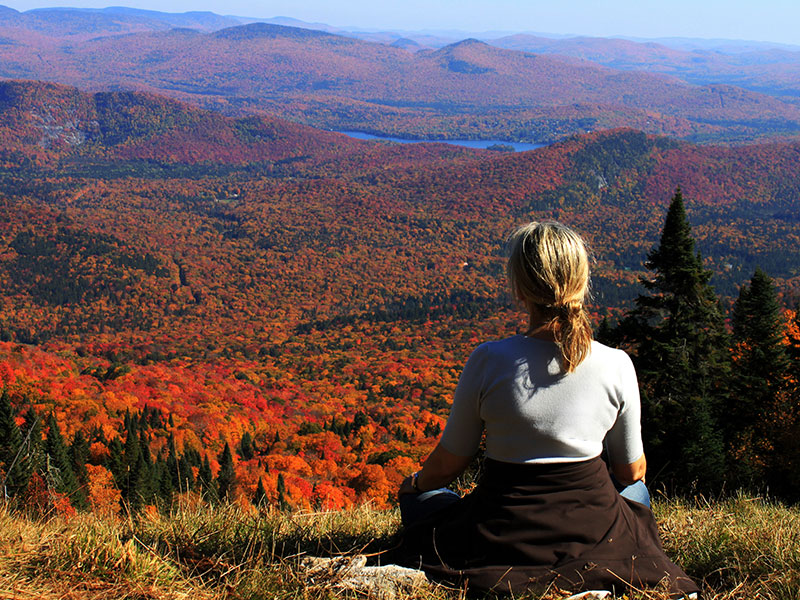 A woman after a breakup, sitting on a mountain meditating.