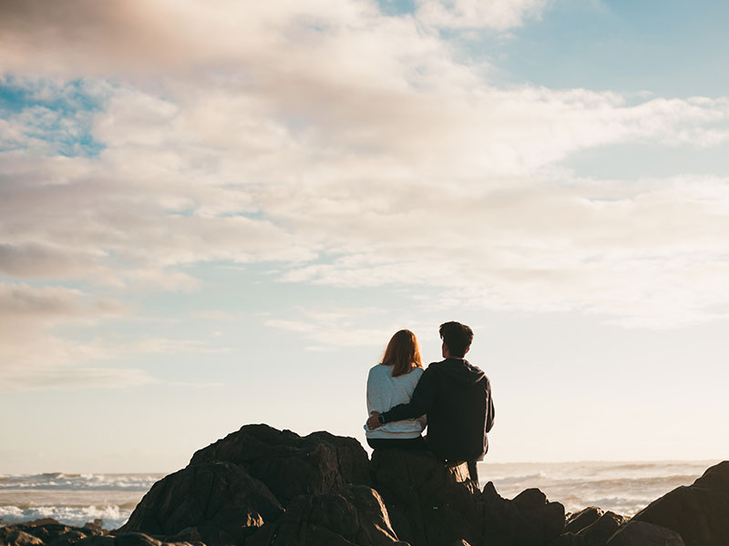 A couple who think it's the right person, wrong time, sitting at the beach talking about their relationship.