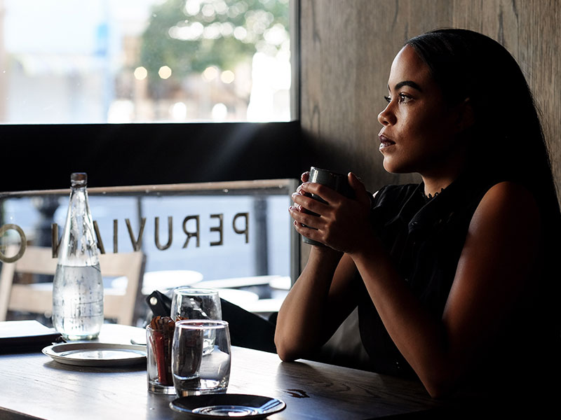 A woman who's getting over a fear of abandonment, drinking coffee and thinking.
