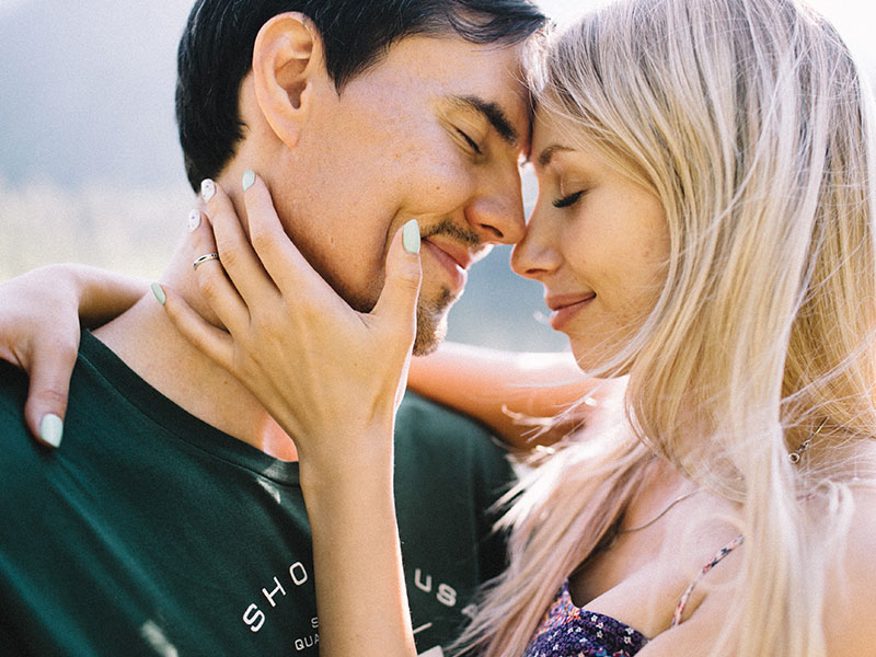 A couple in a healthy relationship, touching noses, about to kiss.