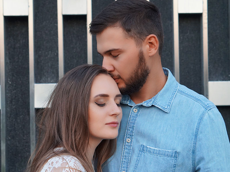 A couple in a rebound relationship hugging each other with their eyes closed.