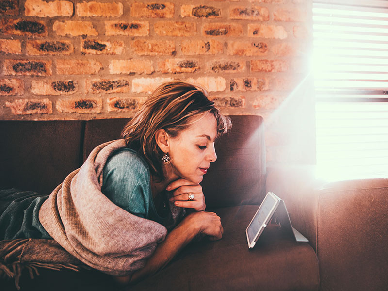 A woman who's ex is in a new relationship, looking at them on Facebook and looking annoyed and upset.