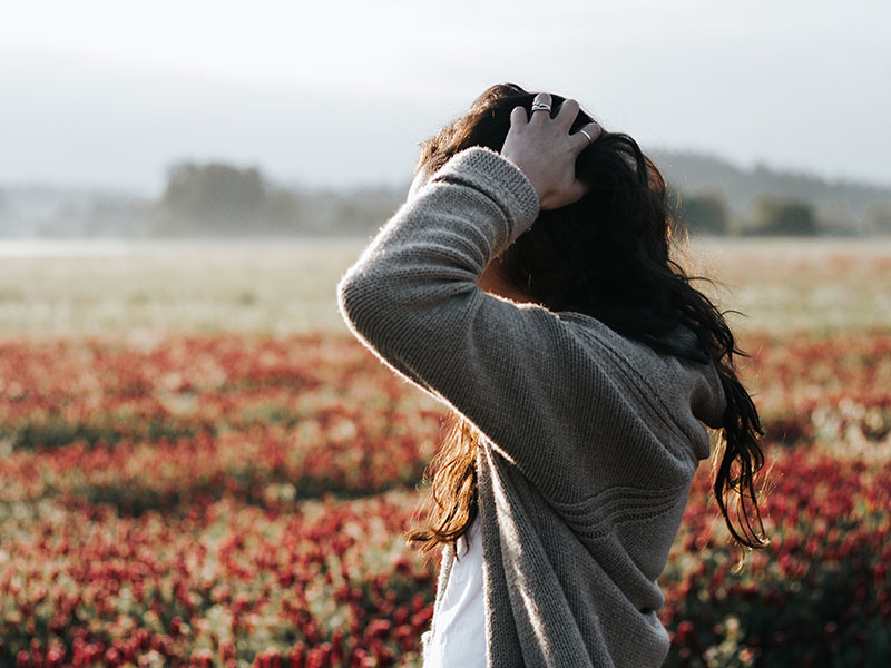 A woman who's feeling relationship anxiety, holding her head in frustration.