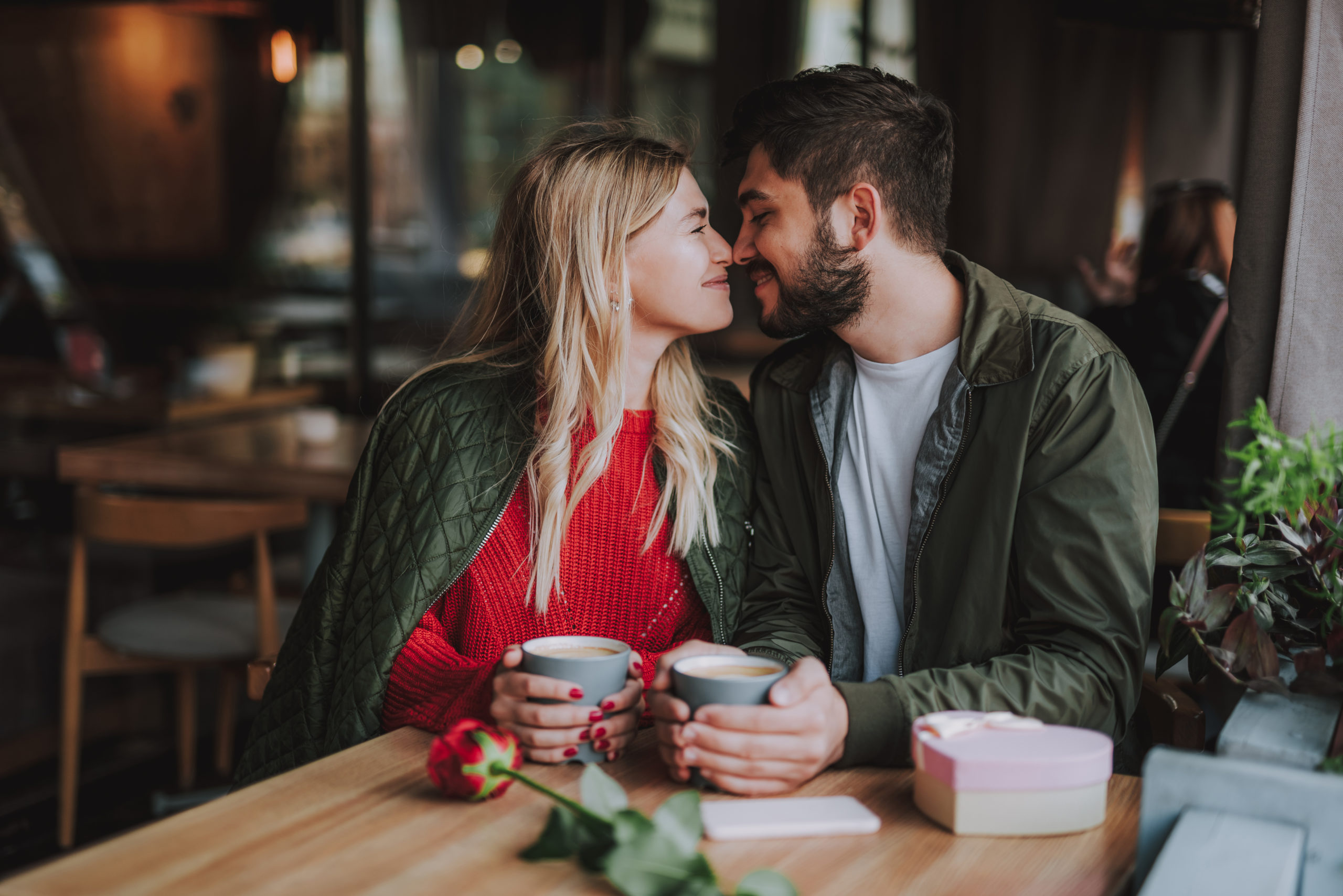 Young, happy couple smiling at each other during a romantic Valentine's Day date idea.