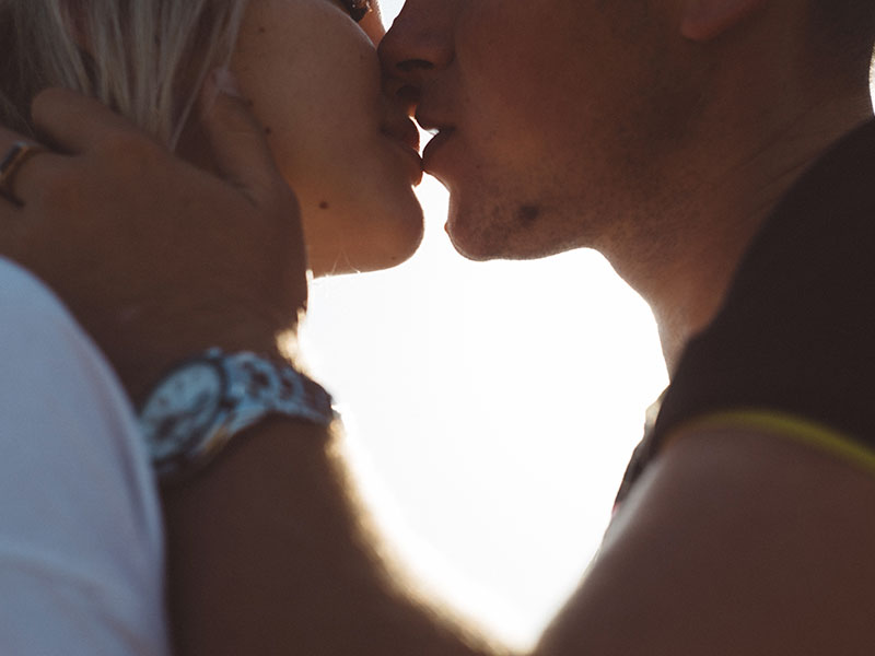 A man who wants to know how to prove you love someone, kissing his girlfriend at twilight.