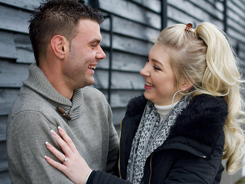 A girl who learned how to tell if a guy is using you, looking at her boyfriend as they hug and wondering how he feels.