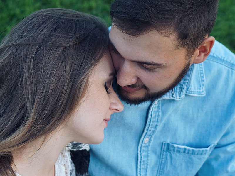 A couple who knows what it's like to be in unhealthy relationships, hugging with their eyes closed, relieved to have found each other.
