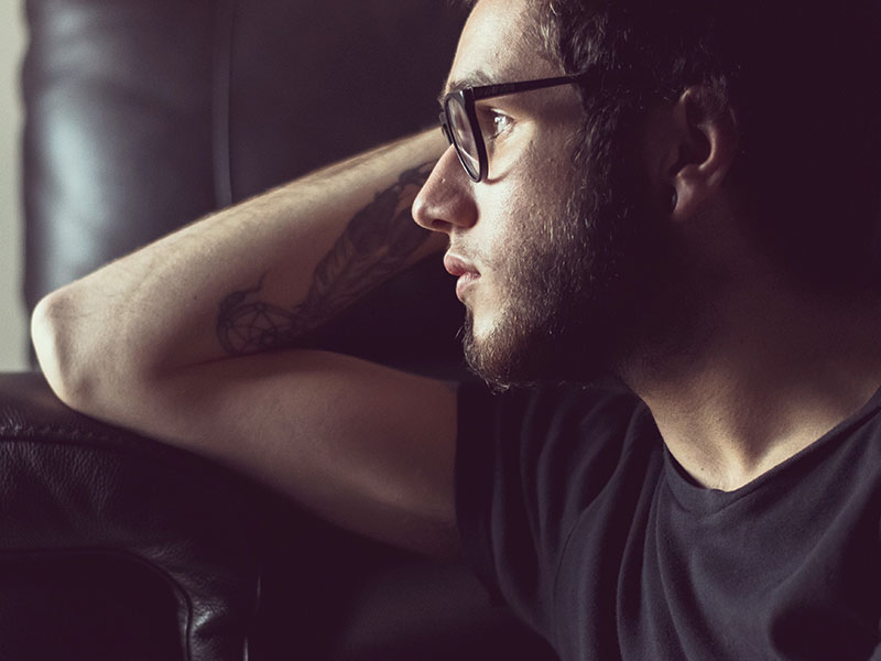 A man suffering from unrequited love looking out the window and thinks.