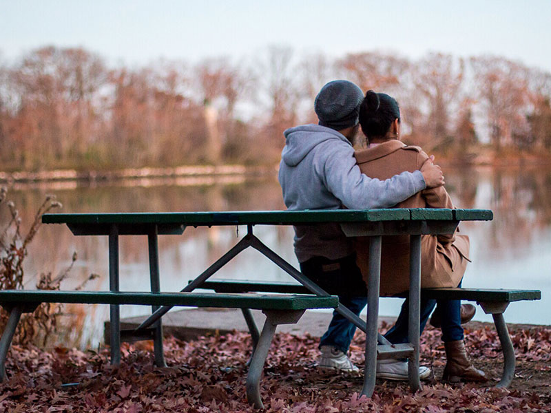 A couple sitting on a park bench.
