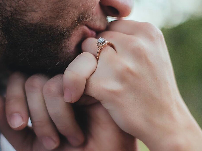 A man kissing a woman's hand and giving her a hand kiss.