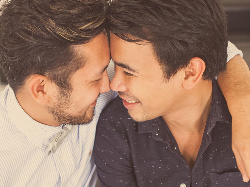 A couple in a new relationship laughing and hugging each other as they touch noses.