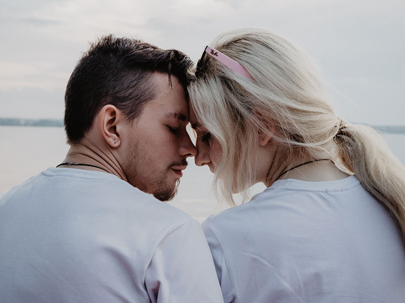 A couple who has a fear of intimacy leaning against each other and thinking.