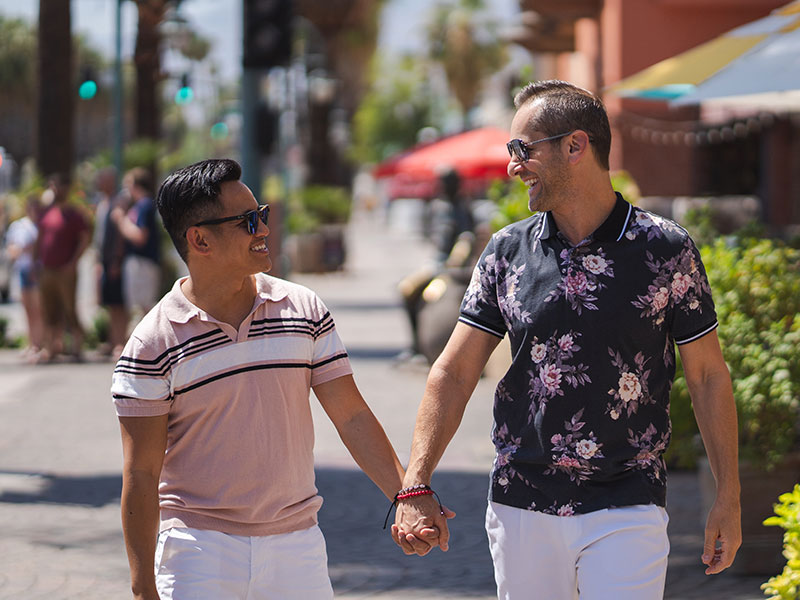 A couple walking down the street during a first date and laughing.