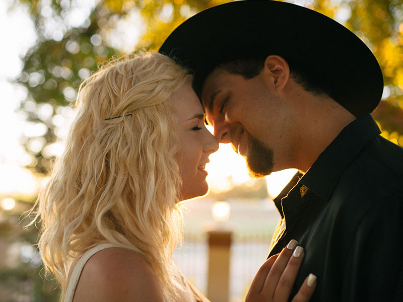 A man who wants to know who do you know when you like someone, kissing his girlfriend outside in the sun.