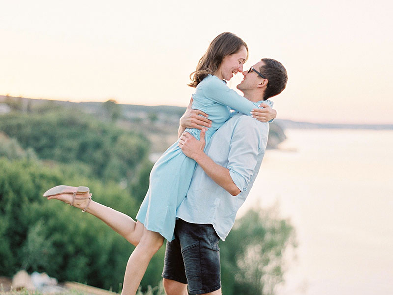 A couple who knows how to show love, laughing as they hug outside.