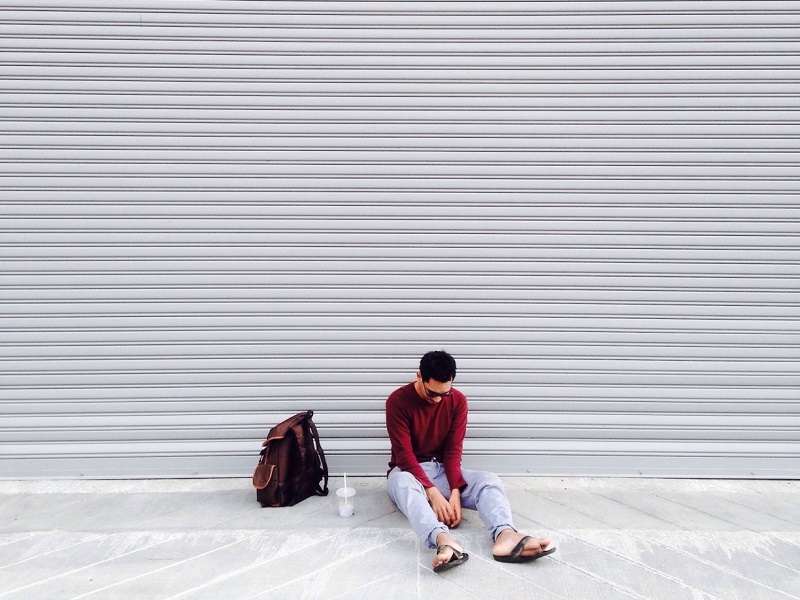 Man sitting in front of garage showing signs that you may be dating an alcoholic