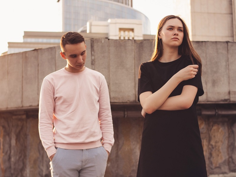 unhappy young couple standing outside showing the risks of being in a relationship with a narcissist