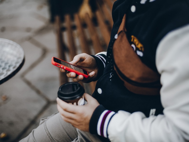 man using mobile phone on a dating app thinking of things to ask a girl