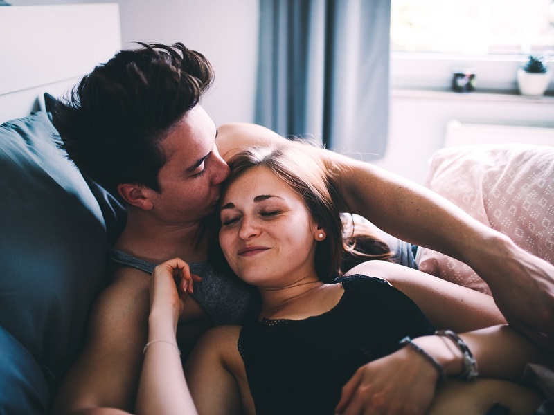 couple laughing together in bed and improving their sex life