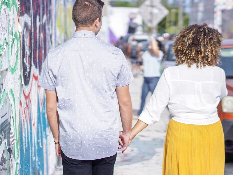 Couple walking in street holding hands speaking about trust quotes for relationships