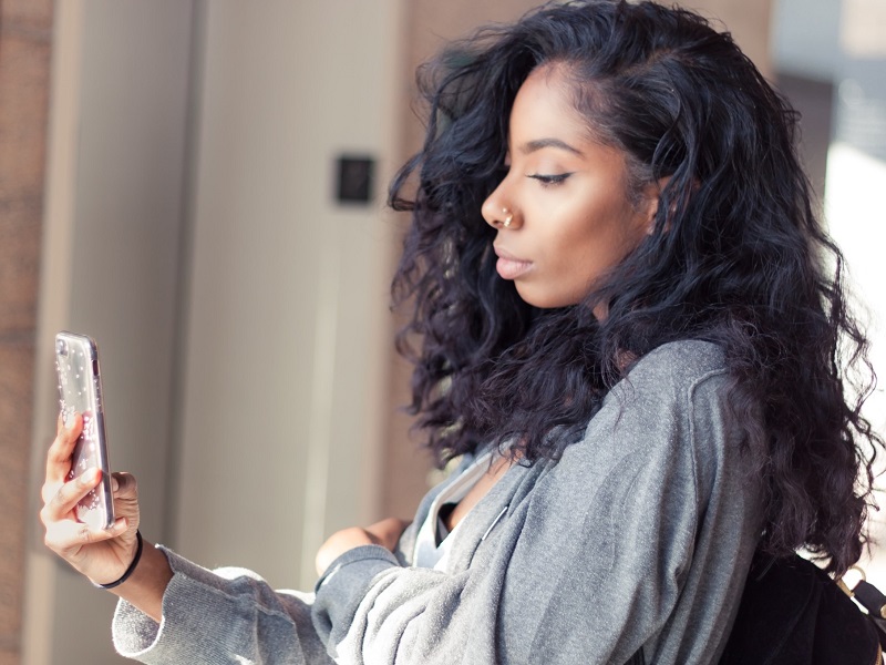 young attractive woman holding mobile phone reading about dating terms