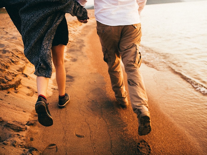 a couple running on the beach showing how to rekindle a relationship