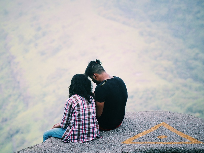couple sitting outdoors on a hike speaking about how to save a relationship