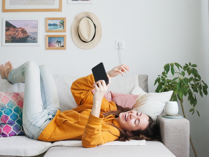 girl-on-couch-laughing-at-witty-dating-profile-examples