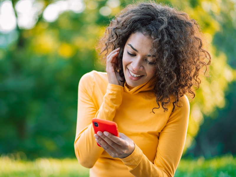 attractive woman using mobile phone to send love texts for him